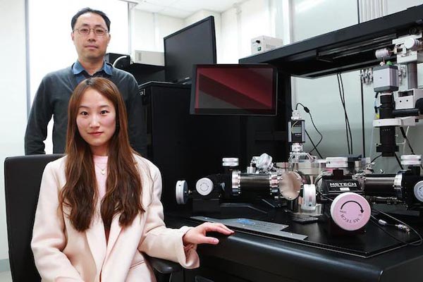 Jae Eun Jang教授(后面)和Su Jin Heo女士(前面)在他们的实验装置旁边，这使他们能够观察细柔性导体中的裂纹是如何形成的。